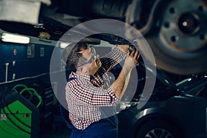 Auto mechanic working in garage. Repair service