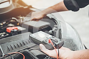 Auto mechanic working in garage Technician Hands of car mechanic working in auto repair Service and Maintenance check car battery