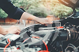 Auto mechanic working in garage Technician Hands of car mechanic working in auto repair Service and Maintenance check car battery