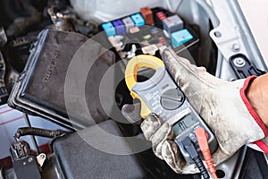 Auto mechanic working in mechanics garage, Technician checking fuse and relay on car engine, Repair and Maintenance service