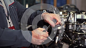 An auto mechanic works on a car engine in the mechanics & x27; garage. Repair services. Close-up