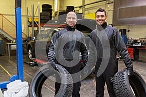 Auto mechanics changing car tires at workshop