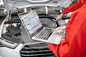 Auto mechanics doing diagnostics with laptop