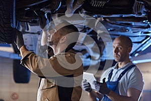 Auto Mechanics Inspecting Car