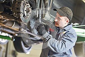 Auto repair service. Mechanic inspecting car suspension