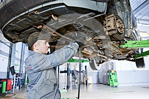 Auto repair service. Mechanic works with car suspension