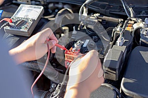 Auto repair technician has inspected the condition of the engine using ammeter