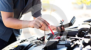 Auto repair technician has inspected the condition of the engine using ammeter