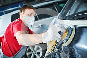 Auto repairman grinding autobody