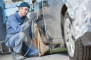 Auto repairman grinding autobody bonnet