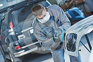 Auto repairman grinding autobody bonnet