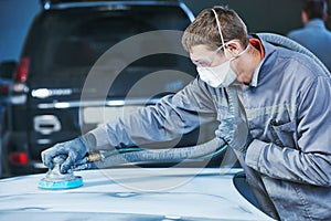 Auto repairman grinding autobody bonnet