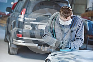 Auto repairman grinding autobody bonnet