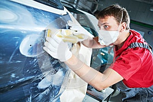 Auto repairman grinding automobile body