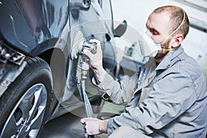 Auto repairman grinding automobile car body