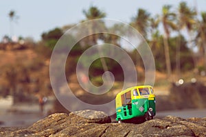 Auto rickshaw driving past palm tree forest in India. Public transport model in natural landscape of Asia