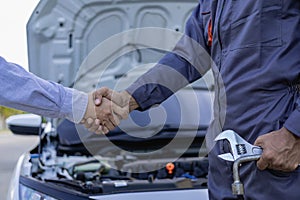 At Auto Service. Cropped view of auto mechanic and customer holding hands, car repair, maintenance,