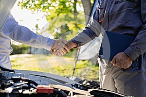 At Auto Service. Cropped view of auto mechanic and customer holding hands, car repair, maintenance,