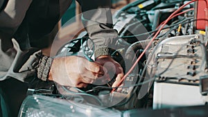 Auto service, repair, maintenance concept. Auto electrician troubleshooting a car engine. Auto electrician working on