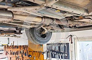 Auto service shop has lift for easy working on underside of car