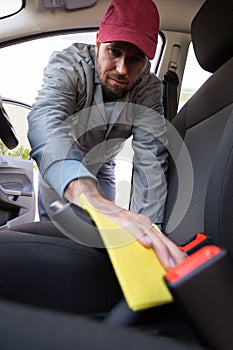 Auto service staff cleaning car interior