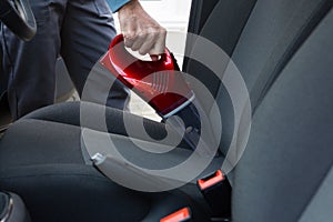 Auto service staff cleaning car with portable vacuum