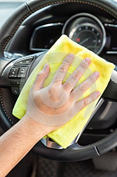 Auto service worker cleaning inside car with micro fiber cloth