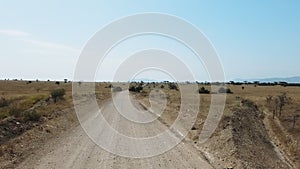 Auto travel: SUV rides savannah, a valley with mountains on the horizon. POV - Point of view car moving along the road