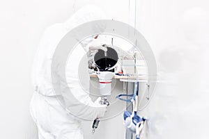 Auto worker preparing black paint for bodywork