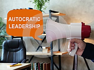 Autocratic leadership concept. Loudspeaker in hand and sign.