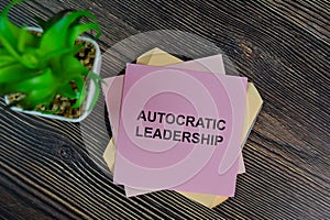 Autocratic Leadership write on sticky notes isolated on Wooden Table