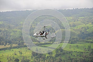 Autogyro flying above the tropical landscape