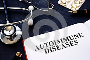 Autoimmune diseases. Book, pills and stethoscope on the desk.