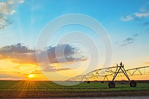 Automated farming irrigation system in sunset