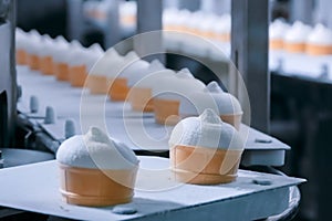 Automated technology concept - conveyor belt with icecream cones at food factory