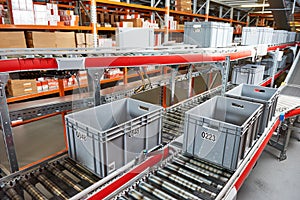 Automated warehouse. Boxes with spare parts moving on conveyer
