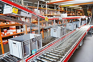 Automated warehouse. Boxes with spare parts moving on conveyer