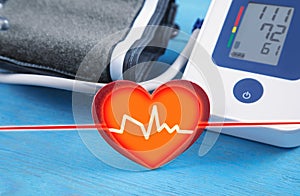 Automatic blood pressure meter and red heart on blue background