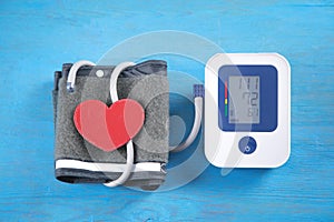 Automatic blood pressure meter and red heart on the blue background