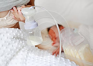 Automatic breast pump. Mothers breasts milk for newborn baby in bed room at home