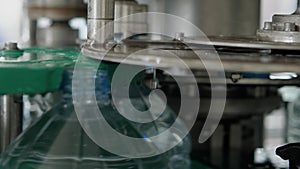 Automatic capping machine for plastic bottles with a volume of 5 liters close-up. Production of drinking water at a food processin