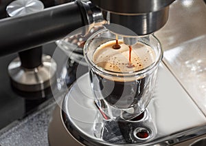 Automatic coffee machine. Pouring coffee into the coffee cup closeup