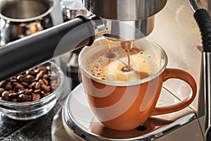 Automatic coffee machine. Pouring coffee into the coffee cup closeup photo
