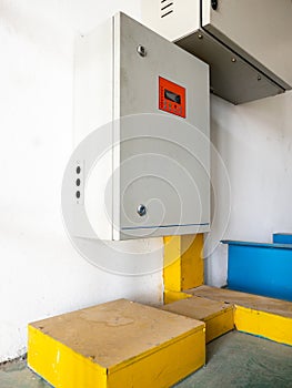 The automatic control box near the white wall.