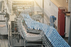 Automatic conveyor line or belt with glass bottles at brewery production. Industrial beer bottling equipment machinery