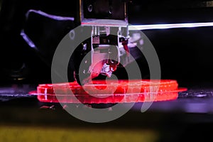 Automatic 3D printer machine printing red flat plastic model: close up