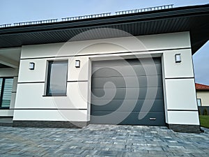 Automatic electric roll-up commercial garage gate or push-up door in modern private building ground floor