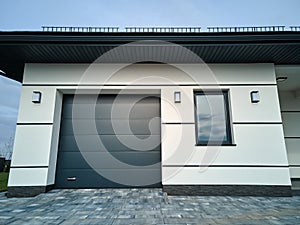 Automatic electric roll-up commercial garage gate or push-up door in modern private building ground floor