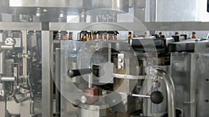 automatic equipment for gluing labels on glass beer bottles on packing workshop, moving conveyor