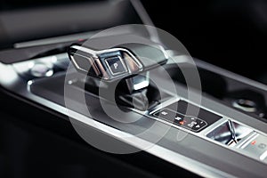 Automatic gear stick of a modern car, car interior details.